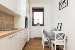 une cuisine avec une table et des chaises ainsi qu'une fenêtre dans l'établissement Wola Business Apartments, à Varsovie