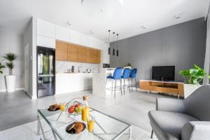 a living room filled with furniture and a kitchen at ZLOTA Luxury Apartments in Warsaw