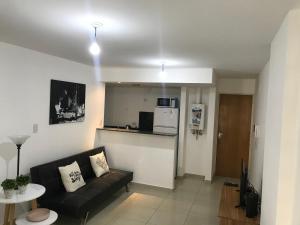 ein Wohnzimmer mit einem Sofa und einer Küche in der Unterkunft Jardines del Boulevard 2 in Cordoba
