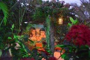 a garden with a large painting of two men at Pousada Peixe D'Ouro in Jericoacoara