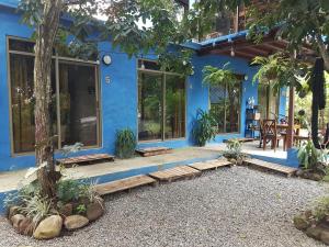 una casa blu con un albero di fronte di The Blue House Panama a Chame