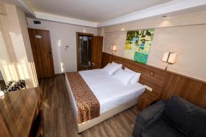 イスタンブールにあるBGuest Hotel & Residenceのベッドとソファ付きのホテルルーム
