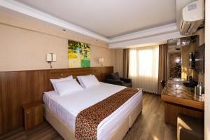 una camera d'albergo con un grande letto e una scrivania di BGuest Hotel & Residence a Istanbul