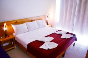 a bedroom with a bed with two towels on it at Pousada Peixe D'Ouro in Jericoacoara