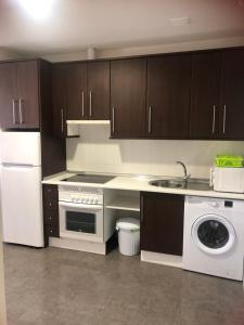 a kitchen with a white refrigerator and a dishwasher at Estudio con piscina y Wifi in Ciudad Real