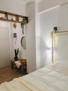 Schlafzimmer mit einem weißen Bett und einem Spiegel in der Unterkunft White Tundra Studio in Athen
