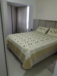 ein Schlafzimmer mit einem Bett in einem Zimmer mit einem Fenster in der Unterkunft Balneário Camboriú in Balneário Camboriú