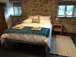 - une chambre avec un lit et des serviettes dans l'établissement Dan y Graig Barn, Carmarthen, à Carmarthen