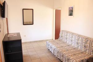 uma sala de estar com um sofá e um espelho em Apartments and rooms Jagoda - comfy and cozy em Zadar