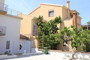 uma casa com uma árvore em frente em Apartments and rooms Jagoda - comfy and cozy em Zadar