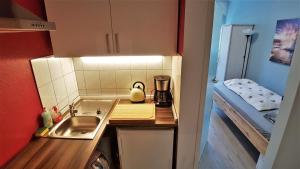 a small kitchen with a sink next to a bed at Apartment Weinsberg in Cologne