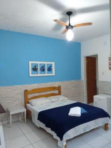 a bedroom with a bed and a ceiling fan at Suítes Veleiro in Ubatuba