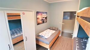 een kleine kamer met een bed en twee stapelbedden bij Apartment Weinsberg in Keulen