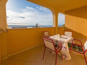 een tafel en stoelen op een balkon met uitzicht op de oceaan bij Apartments ROKO in Crikvenica