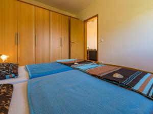 twee bedden in een slaapkamer met houten kasten bij Apartments ROKO in Crikvenica
