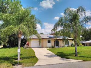 a house with two palm trees and a driveway at Vacation Home Falcon in Lehigh Acres
