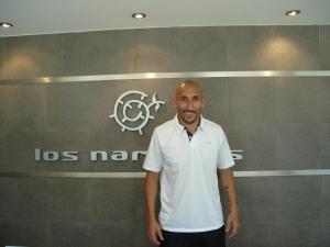 a man standing in front of a wall with a sign at Hotel Los Naranjos in General Deheza