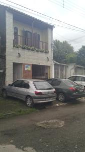 three cars parked in a parking lot in front of a building at Suítes Veleiro in Ubatuba