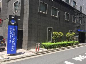 a building with a blue sign on the side of a street at HOTEL MYSTAYS Kamata in Tokyo