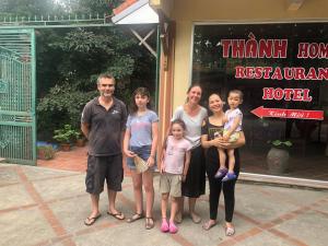 a family posing for a picture in front of a hotel at Tam Coc - Thành Homestay in Ninh Binh