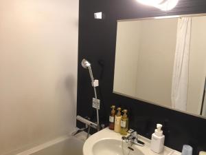 a bathroom with a sink and a mirror at HOTEL MYSTAYS Kamata in Tokyo