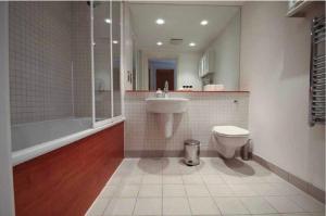 a bathroom with a sink and a toilet and a tub at SIAC Barbican Farringdon in London