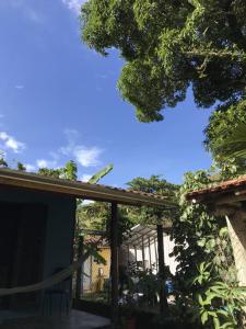 een veranda van een huis met een hek en bomen bij Suítes Canto do Nema in Ilhabela