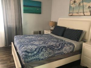 ein Schlafzimmer mit einem Bett mit einer blauen und weißen Decke in der Unterkunft Hollywood Beachfront House in Hollywood