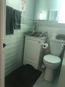 a bathroom with a white toilet and a sink at Hollywood Beachfront House in Hollywood