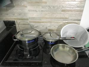 a stove with two pots and a fan on it at Apart Hotel Marinas Tamandaré in Tamandaré