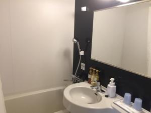 a bathroom with a white sink and a mirror at HOTEL MYSTAYS Kamata in Tokyo