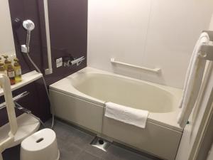 a bathroom with a bath tub and a toilet at HOTEL MYSTAYS Kamata in Tokyo