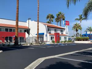 an empty street in front of a building with palm trees at SureStay Plus Hotel by Best Western Chula Vista West in Chula Vista