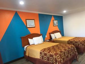 a room with two beds and an orange and blue wall at Americas Best Value Inn Bowie in Bowie