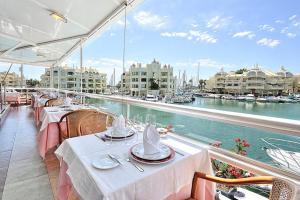 un balcón con mesas y sillas en un barco en Apartament Benalmadena Marina SOL, en Benalmádena