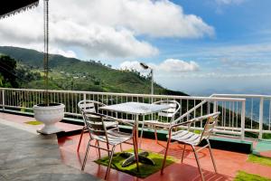 a patio with a table and chairs on a balcony at The Mist Holiday Bungalow in Haputale