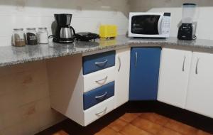 a kitchen with blue and white cabinets and a microwave at Casa Vermelha in Ouro Preto