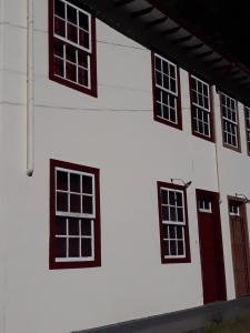 a white building with red windows on it at Casa Vermelha in Ouro Preto