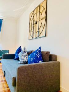 a living room with a couch with a clock on the wall at Best Apartment in Paços de Arcos in Paço de Arcos