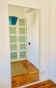 a mirror reflection of a room with a door at Best Apartment in Paços de Arcos in Paço de Arcos