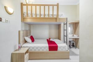 a bedroom with a bunk bed with a red blanket at RedDoorz near Jogja National Museum in Yogyakarta