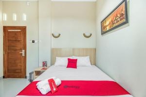 A bed or beds in a room at RedDoorz near Jogja National Museum