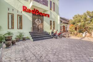 a building with a motorcycle parked outside of it at RedDoorz near Jogja National Museum in Yogyakarta