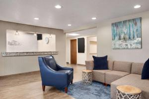 a waiting room with a couch and a chair at Baymont by Wyndham Mt. Pleasant in Mount Pleasant