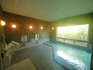 une grande salle de bains avec une piscine et une fenêtre dans l'établissement Hotel Route-Inn Court Minami Matsumoto, à Matsumoto