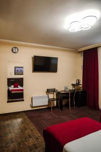 ペトロパブロフスク・カムチャツキーにあるKlyuchotelのベッド、テーブル、テレビが備わる客室です。