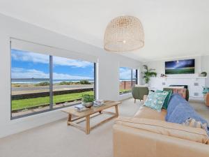 a living room with a couch and a view of the ocean at 10 OCEAN VILLA in Port Fairy