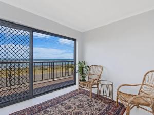 a room with two chairs and a balcony with a view at 10 OCEAN VILLA in Port Fairy