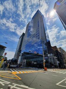 a tall building with mirrored windows on a city street at Ramada Encore by Wyndham Busan Station in Busan