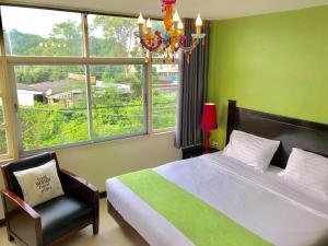 una camera con letto, lampadario a braccio e finestra di Baan Nilawan Hua Hin Hotel a Hua Hin